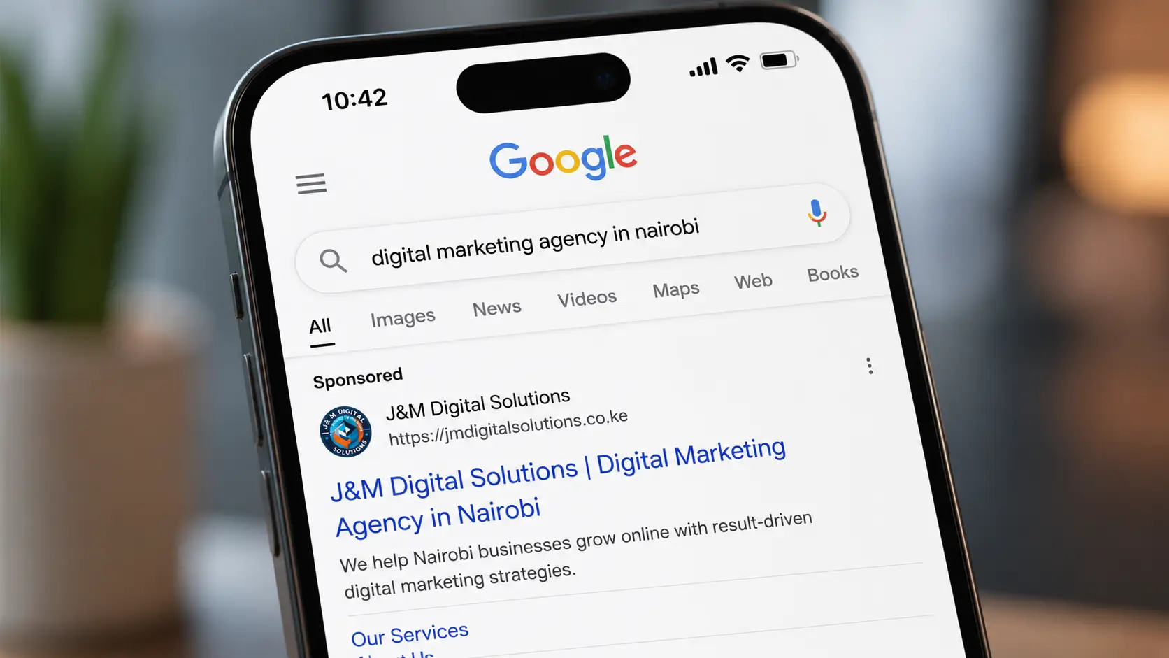 Close up of a Google search results page on a smartphone showing a sponsored ad listing for a Kenyan business