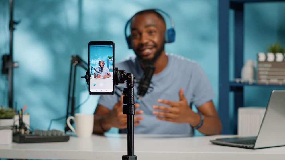 Kenyan entrepreneur filming TikTok business content on a smartphone showing products in their shop